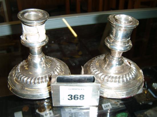 Pair Edwardian silver candlesticks (a.f) and a silver match box case(-)